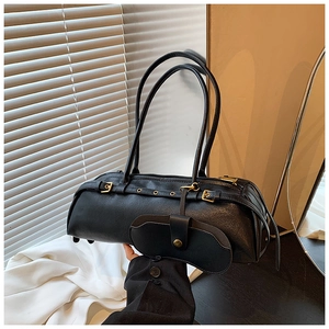 Detail of black leather barrel bag with punk metal eyelets and detachable mini pouch