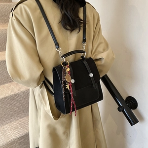 Minimalist black square backpack with tennis racket charm and woven details for women