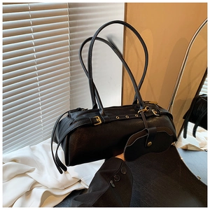 Detail view of black vintage baguette bag with gold rivets and mini accessory pouch