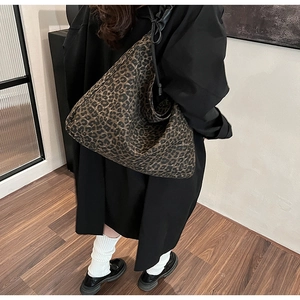 Detail view of large leopard print tote bag showing texture and shoulder strap design
