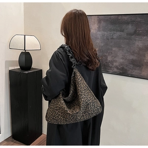 Detail showing vintage leopard print tote bag with black pleated leather shoulder strap