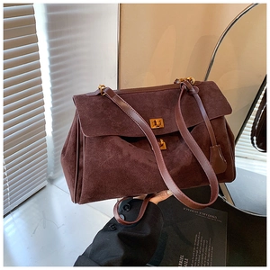 Detail of coffee brown suede tote bag featuring a vintage gold twist lock and fine texture