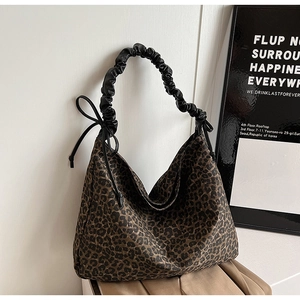 Detail of leopard print tote bag with black pleated shoulder strap and bow drawstring