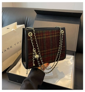 Dettaglio borsa a tracolla in tweed scozzese con catena dorata e confezione regalo
