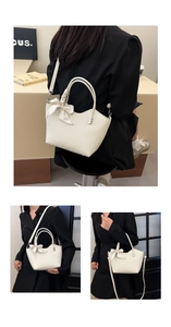 Détail du sac seau blanc crème avec nœud en soie et rivets en forme de cœur