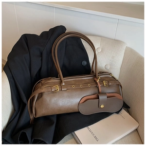 Detail of dark brown vintage Boston bag with gold eyelets and hanging glasses case