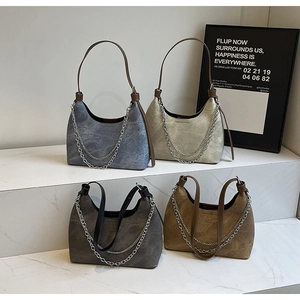 Nahaufnahme von Hobo-Taschen aus Kunstleder mit Vintage-Textur und Metall-Doppelketten