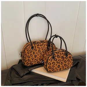 Detailansicht der Leopard-Print-Taschen auf Leder und Buchoberfläche im Set-Design