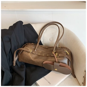 Detail of vintage brown shoulder bag with metal eyelets and detachable mini pouch