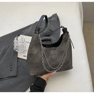 Nahaufnahme der grauen Wildleder-Hobo-Bag mit silberner Kette und schwarzem Griff