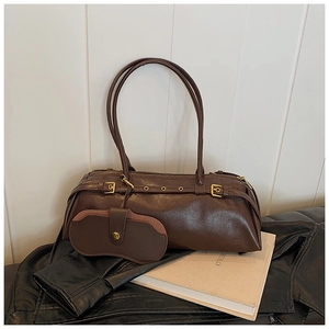 Detail of vintage dark brown Boston bag with metal buckles and detachable mini pouch