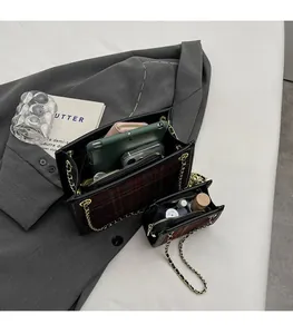 Dettaglio della borsa a quadri rossa e nera con catena d'oro e spazio interno