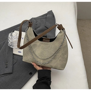 Detailansicht der olivgrünen Canvas-Hobo-Tasche mit Silberketten und Leder-Schultergurt