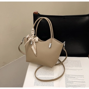 Détail du sac seau kaki grainé avec anse en foulard de soie et boucle coeur argentée