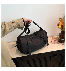 Détails du sac de sport cylindrique noir avec sangles à boucle et texture en nylon robuste