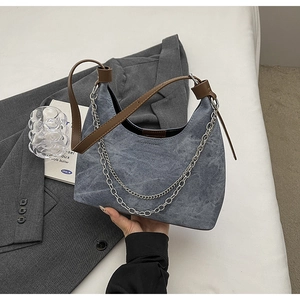 Detail der blauen Denim Hobo Tasche mit silbernen Ketten und braunem Leder Schulterriemen