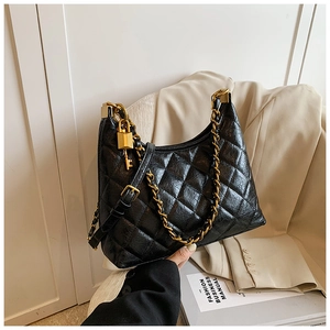 Detailed view of black quilted faux leather bag with gold chain and padlock charm
