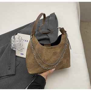 Detail einer braunen Wildleder-Hobo-Bag mit doppelter Silberkette und Leder-Schultergurt