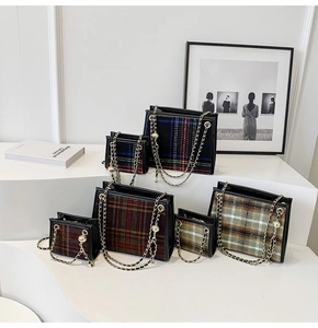 Collection of plaid tweed chain bags in various sizes and autumnal colors displayed on stands