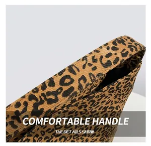 Close-up of durable canvas strap on large leopard print tote bag with thick fabric texture