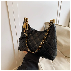 Detail of black quilted leather hobo bag with gold chain strap and metal lock pendant