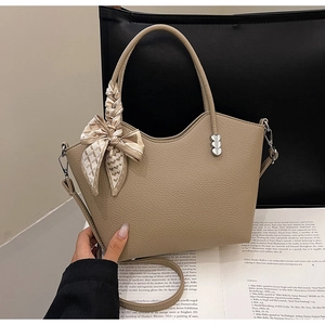 Détails du sac à main kaki en cuir grainé avec accents métalliques en forme de cœur