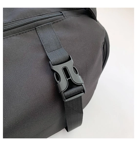 Détail de la boucle en plastique et de la sangle en nylon sur un sac de sport noir