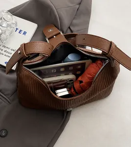 Detail of large brown pleated leather bag showing spacious interior with daily essentials