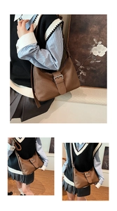 Detailed view of a brown vintage crescent hobo bag with striped texture and buckle strap