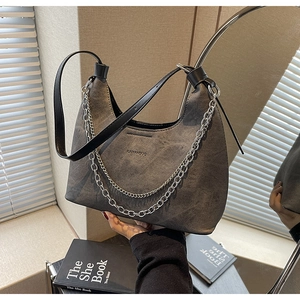 Detail der grauen Denim Hobo-Tasche mit Silberkette und Ledergriff im Fokus