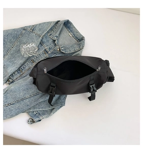 Vue du sac bandoulière noir en nylon spacieux avec boucle en plastique et fermeture éclair