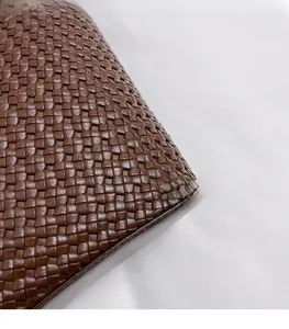 Détail du sac cabas marron tissé montrant la texture du cuir et les finitions