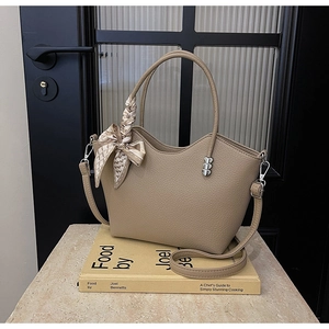 Vue détaillée du sac beige en cuir grainé avec breloques cœurs et décor de foulard en soie