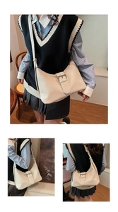 Detail view of cream vintage underarm bag featuring fine textured fabric and metal buckle
