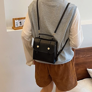 Minimalist black vintage leather backpack for women featuring elegant gold buckle and top handle