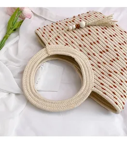 Détail du sac de plage tissé avec pois, perles en bois et pompons décoratifs
