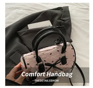 Détail du sac cylindre en seersucker rose avec nœud en satin noir et texture