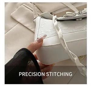 Detailansicht der hochwertigen weißen Lederhandtasche mit floraler Prägung und Nähten
