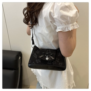 Detailansicht der schwarzen Spitzen-Cloud-Tasche mit Seifenschleife und Herzanhänger