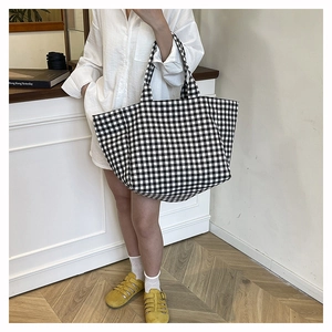 Detailed view of a large black and white checkered canvas tote bag for daily commuting