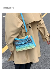 Model wearing a gradient woven crossbody bag in blue and green against a trench coat