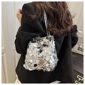 Detail of silver sequin bucket bag with metallic round sequins and woven chain strap