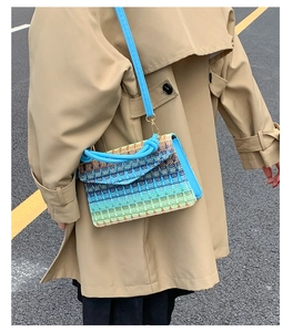 Detail of woven straw bag showing blue gradient texture and vibrant leather strap