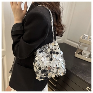 Close-up of a silver sequin bucket bag featuring a metallic chain strap and reflective scales