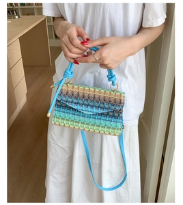 Detail view of rainbow striped woven bag featuring soft cotton texture and knotted handles