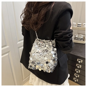 Silver sequin bucket bag with metal chain strap styled with a black blazer and white skirt