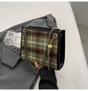 Detail der grün karierten Schultertasche mit goldener Kette und Metallkugel-Dekor