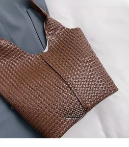 Détail du sac cabas tressé marron foncé avec texture fine et ouverture en V