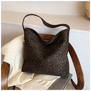 Detail of leopard print tote bag on a wooden chair with a minimalist aesthetic