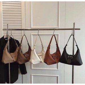Detail view of stylish pleated crescent underarm bags in five versatile colors